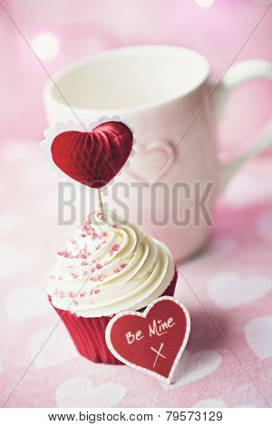 Cupcake decorated with a heart shaped cake pick