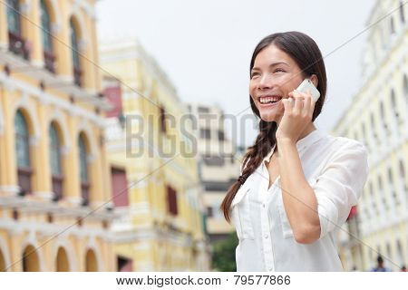 Business woman talking on smart phone in Macau, China. Asian businesswoman using smartphone talking having conversation in Macau on Senado Square or Senate Square.