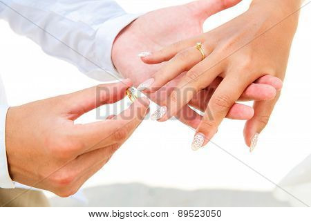 Groom Giving An Engagement Ring To His Bride Under The Arch Decorated With Flowers