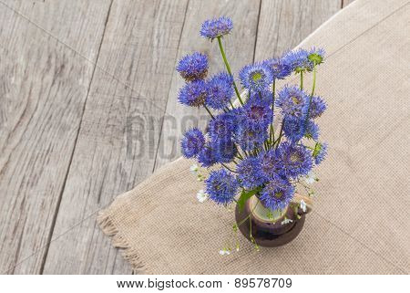 Rustic Still Life With A Bouquet Of Blue Flowers On A Wooden Background