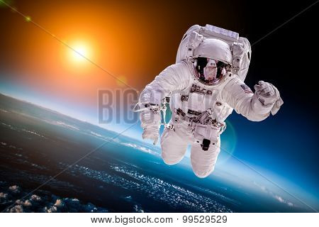 Astronaut in outer space against the backdrop of the planet earth. Elements of this image furnished by NASA.