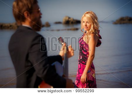 Guitarist Back-view And Blonde Girl Against Sea