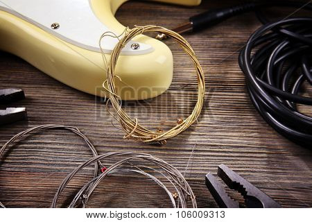 Electric guitar with musical equipment on wooden background