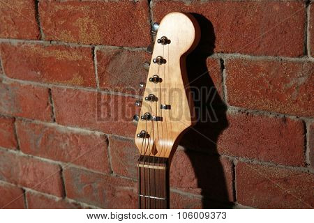 Guitar's fingerboard on brick wall background