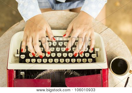 Girl Typing On The Old Typewriter With A Cup Of Coffee Outdoors