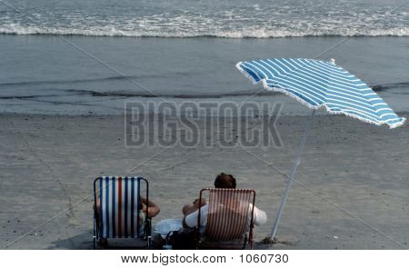 Chairs Umbrella And People  On The Beach