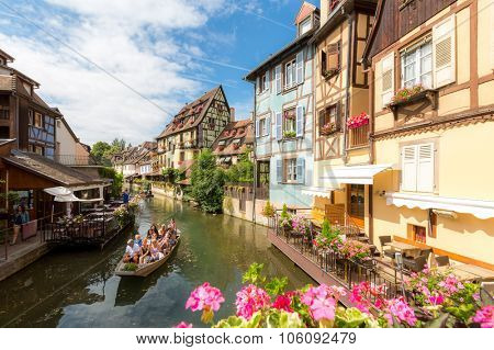 Collar, France- July 13, 2015: Tourist riding boat along canal in Colmar, Alsace, France. The town is situated along the Alsatian Wine Route and considers itself to be the capital of Alsatian wine.