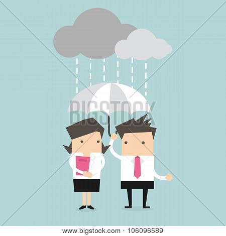 Businessman & businesswoman under umbrella in the rain