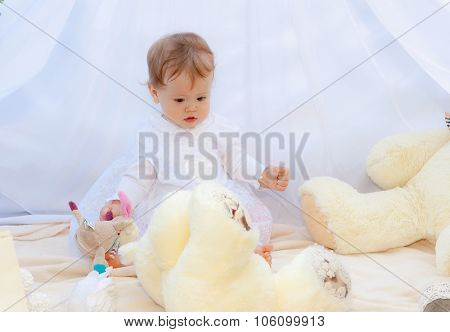Baby playing in a park near the tents of baldachin