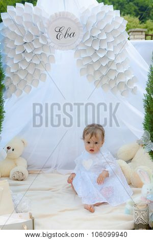 Baby playing in a park near the tents of baldachin
