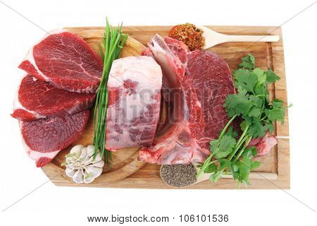 butchery : fresh raw beef lamb big rib and fillet ready to cooking with green stuff on wooden plate isolated over white background