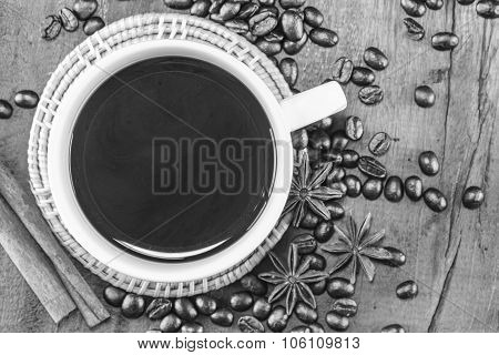 Coffee On The Cup With Coffee Beans And Cinnamon Sticks On Wood Background On Black And White, Selec