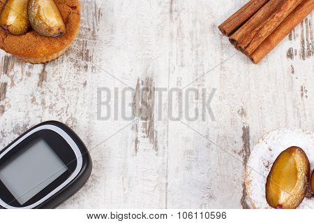 Glucometer, Muffins With Plums And Cinnamon Sticks On Wooden Background, Copy Space For Text