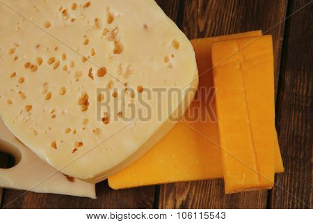 various types of fresh raw aged delicatessen cheese on wooden table cheddar edam swiss