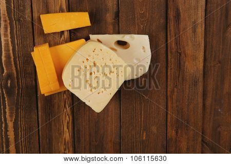 various types of fresh raw aged delicatessen cheese on wooden table cheddar edam swiss