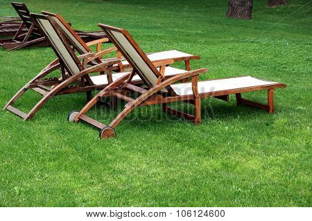 Empty Wooden Weathered Lounger On The Lawn At The Evening