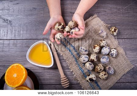 Children's hand holds the eggs of quail.