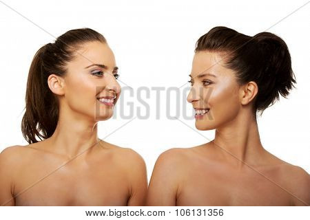 Two attractive topless sisters with make up.