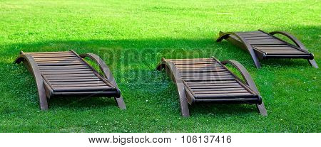 Empty Wooden Weathered Lounger On The Lawn At The Evening