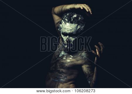 Aboriginal, wild man with white painted face and full body black paint