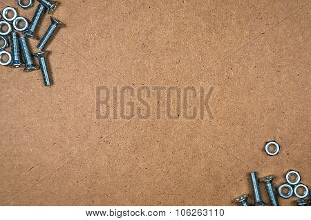 Bolts and nuts on fibreboard