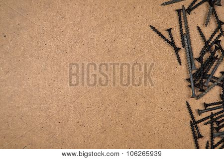 Iron screws on brown fibreboard