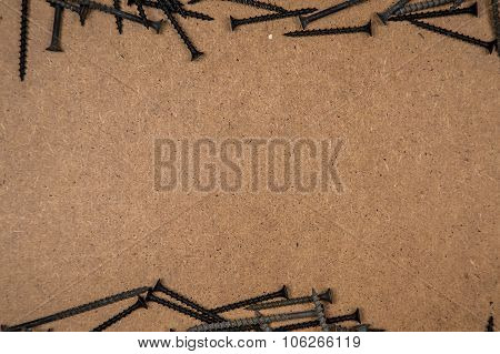 Iron screws on light brown fibreboard
