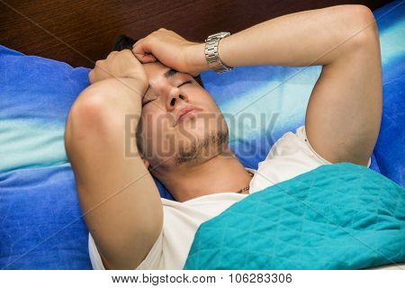 Young with Headache Lying in Bed