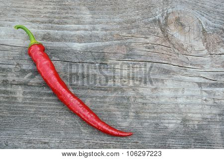 One Hot Pepper On The Old Gray Wooden Board