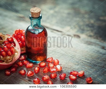 Pomegranate Juice Or Tincture And Garnet Fruit With Seeds On Kitchen Table.