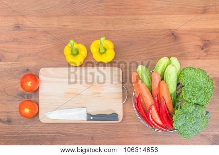 Resh Vegetables And Knife On Cutting Board On Wood Table