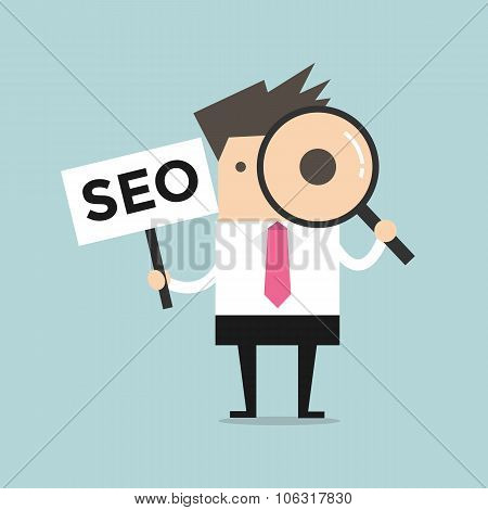 Businessman looking through a magnifying glass with SEO Sign
