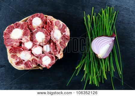 Fresh Raw Beef Oxtail Meat Cut, Ready To Cook. With Vegetable. On Blue Stone  Background.