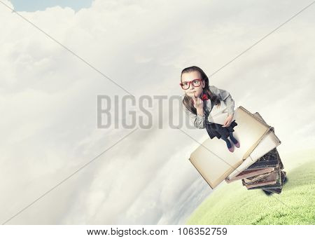 Wideangle picture of funny schoolgirl with paper plane in hand