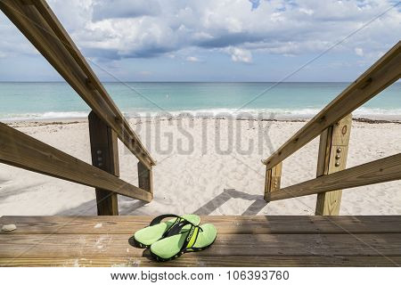 Sandals on wooden steps to the sea