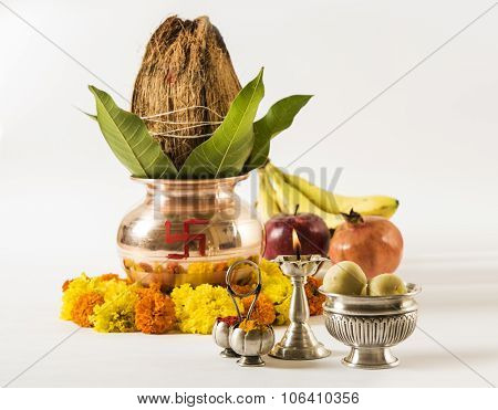 copper kalash with coconut and mango leaf with floral decoration, fruits, diya, sweet pedha,essentia
