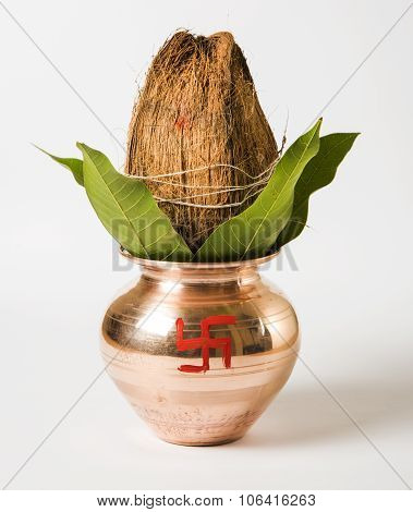 copper kalash with coconut and mango leaf, essential in hindu puja, front view, closeup