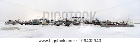 Fishing boats at rest on stands on the shore. Panorama.