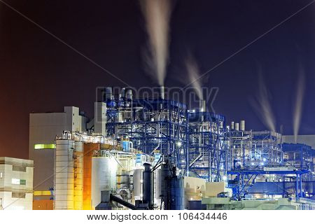 Power station with a steam cloud blown by the wind in a cold starry winter night
