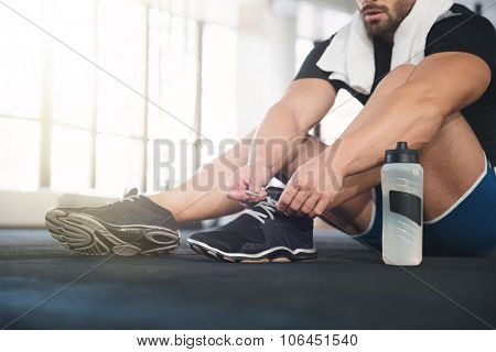 Sportsman ties his black sneakers