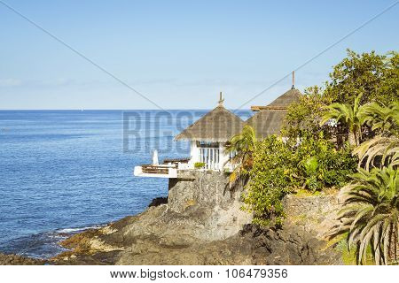Huts With Thatched Roofs On The Edge Of A Cliff By The Sea, Costa Adeje, Tenerife