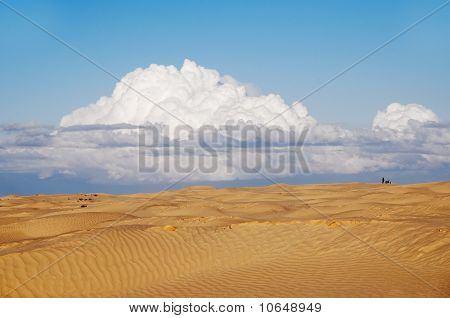 A lonely figure of a man and a motorbike in the desert
