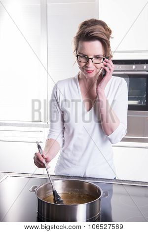 Attractive Woman In Modern Ktchen Cooking And On The Phone