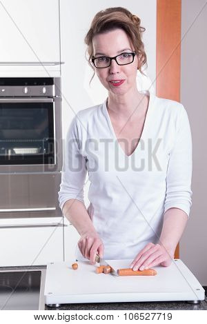 Attractive Woman In Modern Ktchen Cutting Sausage