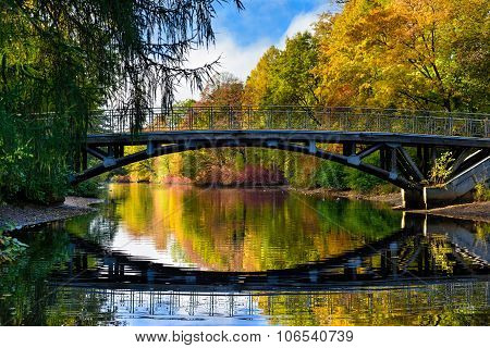 Colorful Autumn In The Park, Old Bridge And Beautiful Water Refl