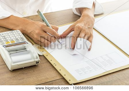 Female Accountant Calculating And Reviewing Numbers On A Receipt