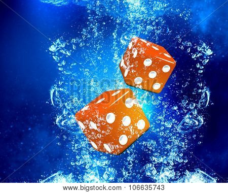 Conceptual image with dice cubes in clear blue water