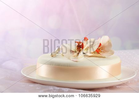 Cake with sugar paste flowers, on light background