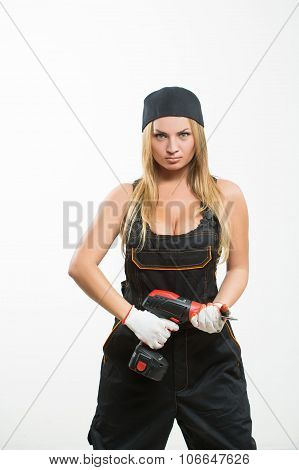 Young sexy female holding a cordless screwdriver