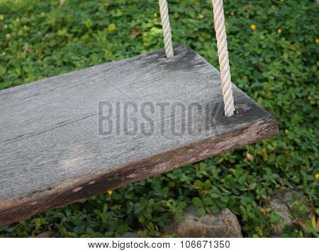 Wood Seat Swing In Green Grass Garden